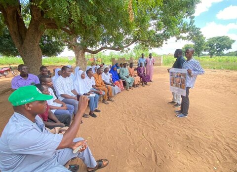 Students gather under a tree in Niger State to learn about NTDs and prepare for MDA. 